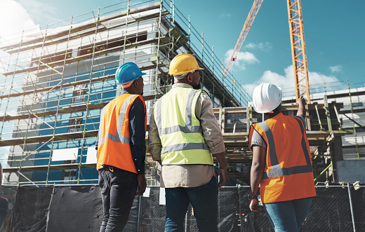 Shot of a group of builders assessing progress at a construction site